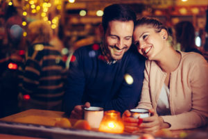 Romantic young couple dating in pub at night